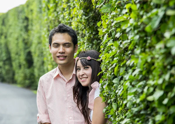 Lovely couple behind the tree — Stock Photo, Image