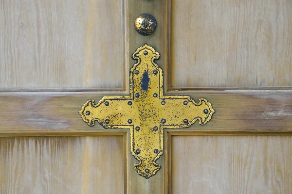 Золотой крест на деревянной стене — стоковое фото