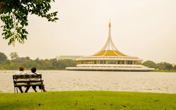 Anciano y ancianas se sientan en el jardín al atardecer — Foto de Stock