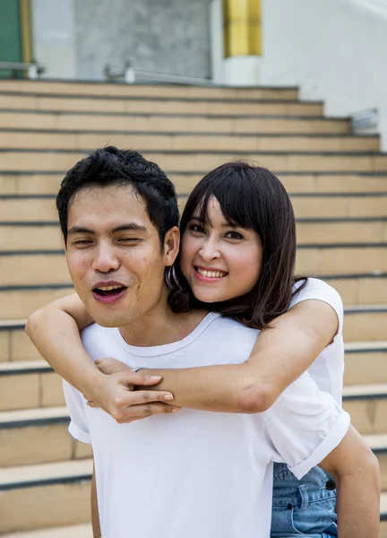 Lovely couple piggy back ride on the stairs6 — Stock Photo, Image