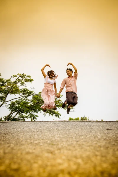 Lovely couple jump on the bridge — Stock Photo, Image