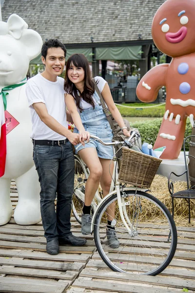 Lovely couple with bicycle in the amusement park2 — Stock Photo, Image