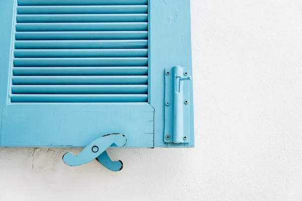 Синее деревянное окно на белых обоях — стоковое фото