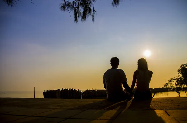 Bella coppia sedersi al tramonto con scena di silhouette3 — Foto Stock