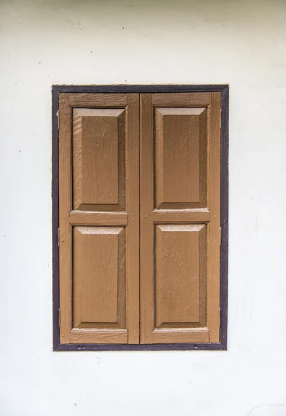 Janela de madeira marrom na parede branca — Fotografia de Stock