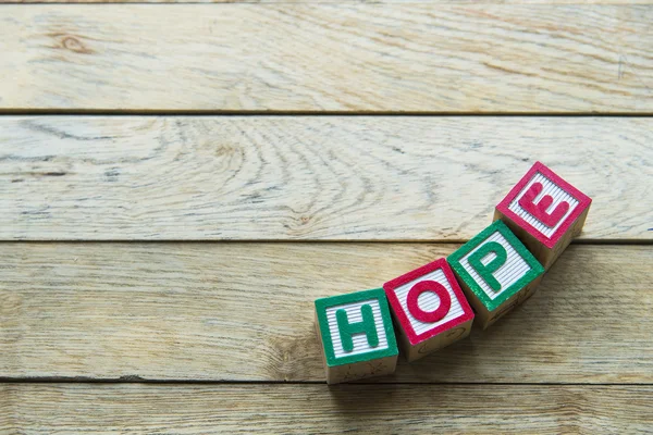 Wooden block word is HOPE on wooden background — Stock Photo, Image