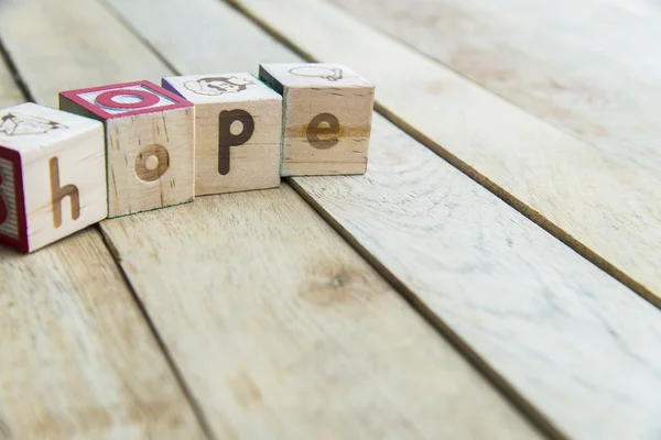 Slovo naděje na dřevěné podlaze jsou dřevěné bloky — Stock fotografie