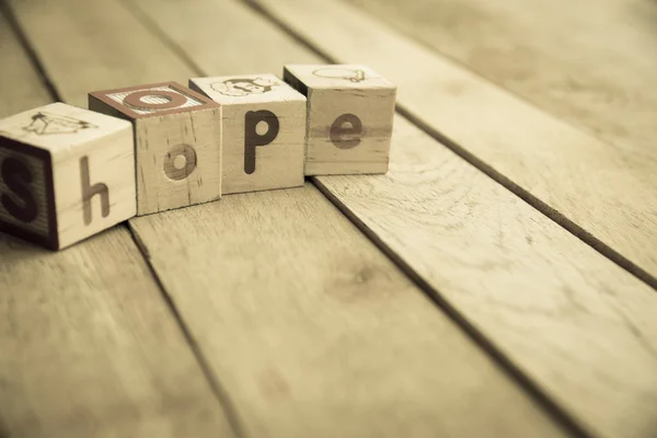 Les blocs en bois sont mot d'espoir sur le plancher en bois3 — Photo