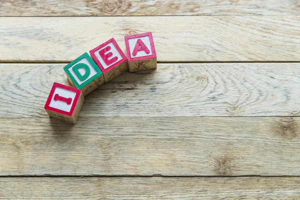 Los bloques de madera son palabra de la idea en el piso de madera —  Fotos de Stock