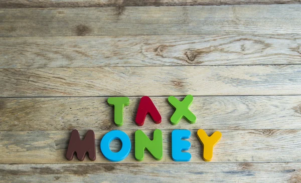 Colorful wooden word Tax and Money on wooden floor — Stock Photo, Image