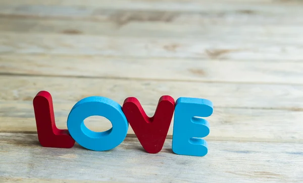 Buntes hölzernes Wort Liebe auf Holzboden 4 — Stockfoto