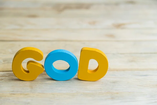 Palabra de madera colorida Dios en el suelo de madera — Foto de Stock