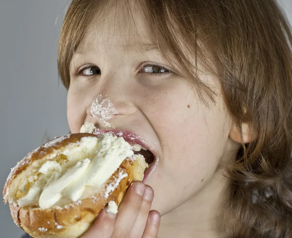 Niño disfrutando de un bollo de crema con pasta de almendras —  Fotos de Stock