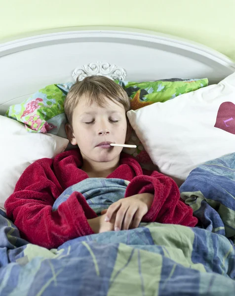 Niño en la cama con fiebre —  Fotos de Stock