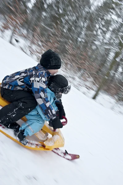 Racing downhills on a snow sledge — Stock Photo, Image