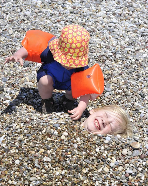 Niños jugando con guijarros en la playa —  Fotos de Stock