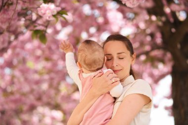 Ebeveyn ve çocuk. Anne bebeğine sarılıyor. Anneler Günü