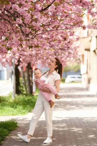 Annem bahar parkında bebeği kollarında tutuyor. 