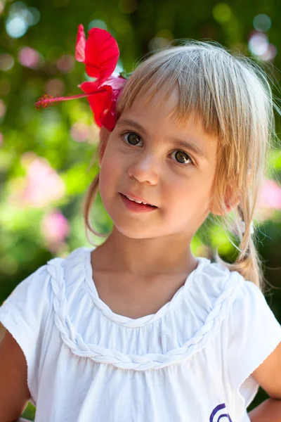 Porträt eines Mädchens, das eine Blume im Haar trägt — Stockfoto