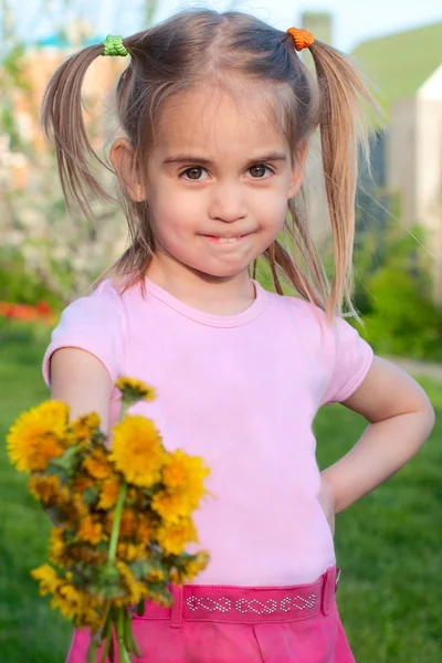Glad liten tjej som håller ut blommor våren utomhus porträtt — Stockfoto