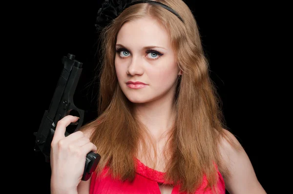 Beautiful girl holding a gun on black background — Stock Photo, Image