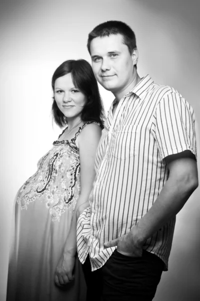 Young caucasian pregnant couple black and white studio portrait