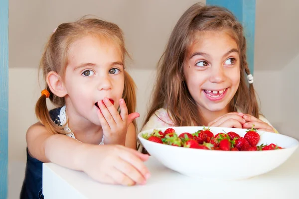 Милые маленькие девочки едят клубнику — стоковое фото