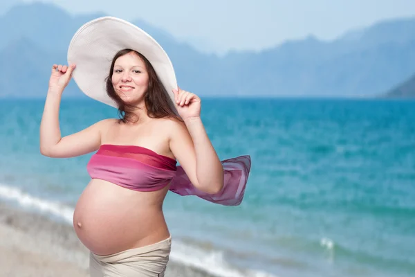 Ευτυχής όμορφη νεαρή έγκυο γυναίκα στην παραλία — Φωτογραφία Αρχείου