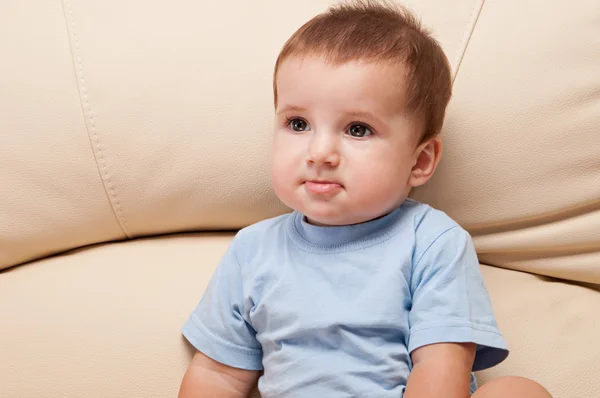 Bonito menino sentado no sofá metade do comprimento retrato — Fotografia de Stock