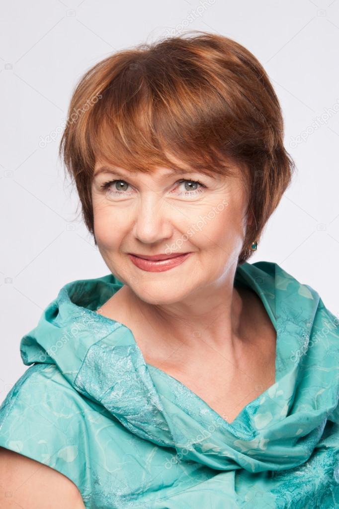 Beautiful fashionable smiling mature woman in turquoise costume