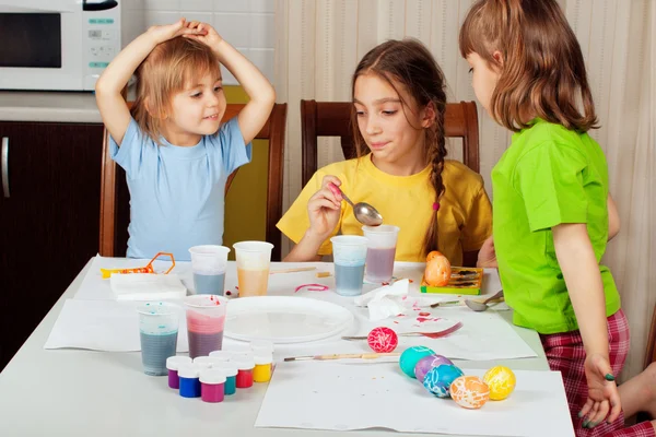 Drie kleine meisjes (zusters) schilderen op Pasen eieren — Stockfoto