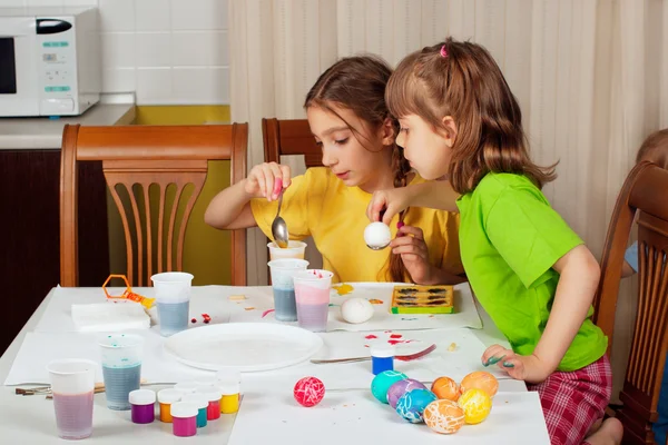 Zwei kleine Mädchen (Schwestern) malen auf Ostereier — Stockfoto