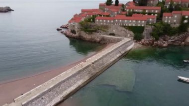 Deniz tarafından yıkanan adaya giden uzun taş köprünün hava manzarası.