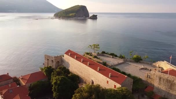 Birds eye view of beautiful bright houses with red roofs. Drone Shot of old town Budva in Montenegro. — Vídeo de Stock