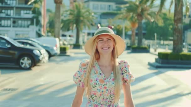 Ευτυχισμένη νεαρή γυναίκα με όμορφο ντύσιμο περπατώντας στο λιμάνι και χαμογελώντας — Αρχείο Βίντεο