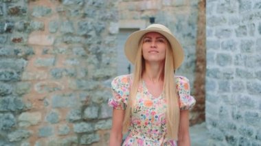 Yaz tatilleri: güneş şapkalı sarışın kadın gezmeye gidiyor.