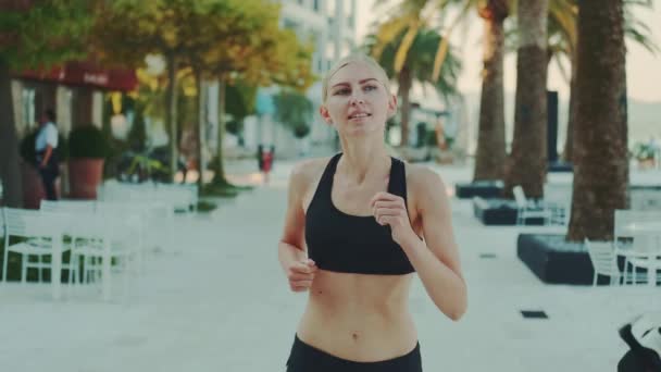 Attractive blonde woman in fitness suit jogging on the street — Stock videók