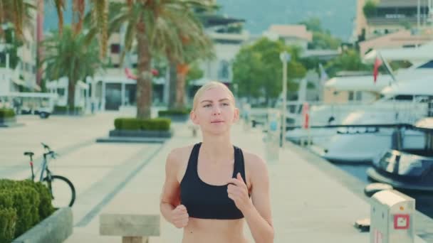 Beautiful woman with blue eyes jogging in fitness suit — Stock videók
