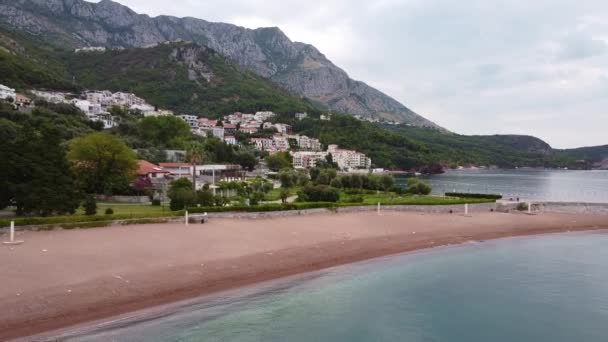 Cottages at the foot of the great mountains by the sea — 图库视频影像