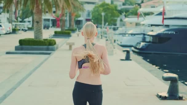Back view of fit girl with long blonde hair jogging — 图库视频影像