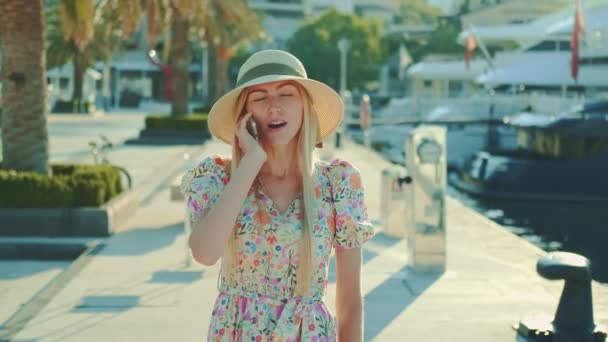 Vrolijke vrouw wandelen op het water en spreken op de smartphone — Stockvideo