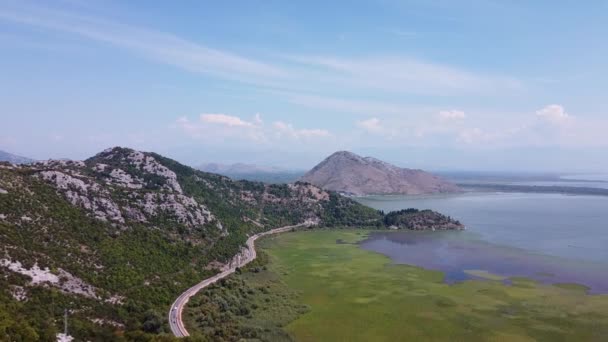 Birds eye view of mountainous terrain with mountain road at the foot — 图库视频影像