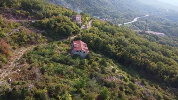 Aerial view of ruined building with red roof in the mountain – stockvideo