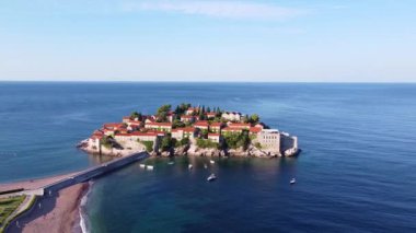 Deniz ufkunun insansız hava aracı görüntüsü ve eski binaları olan küçük bir ada.