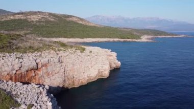 Deniz kıyısında yamaçlı kayalık bir sahil.