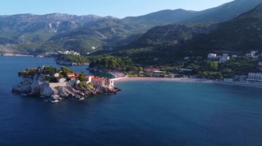Deniz kıyısındaki ormanlarla kaplı görkemli dağların insansız hava aracı görüntüsü.
