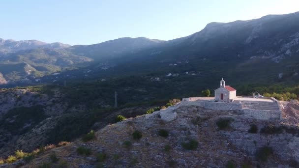 Güneşli ışınlarda kayaların üzerinde bulunan antik kilisenin panoraması — Stok video