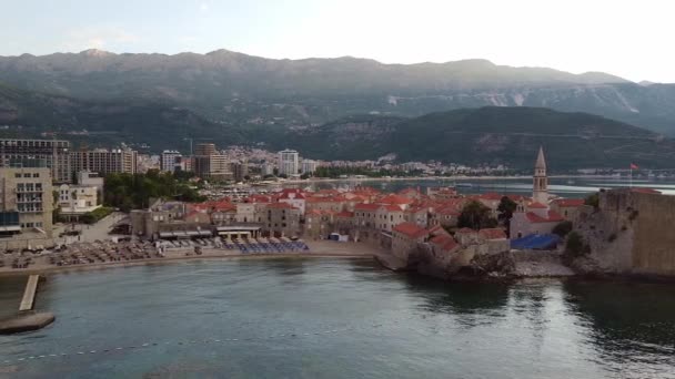 Aerial: coastal city with old ruins. Drone Shot of old town Budva in Montenegro. — Stockvideo