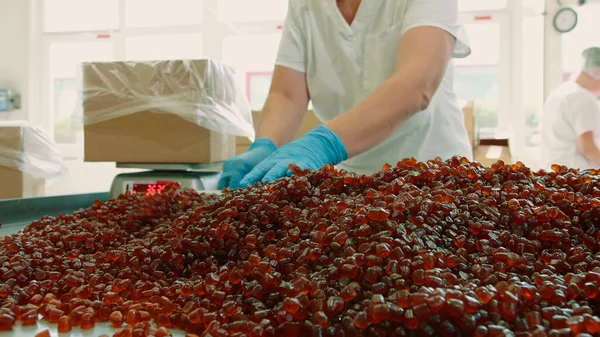 Candy factory. Factory worker packing candies.