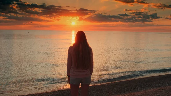 Admirando o nascer do sol na praia mulher levantando as mãos — Fotografia de Stock